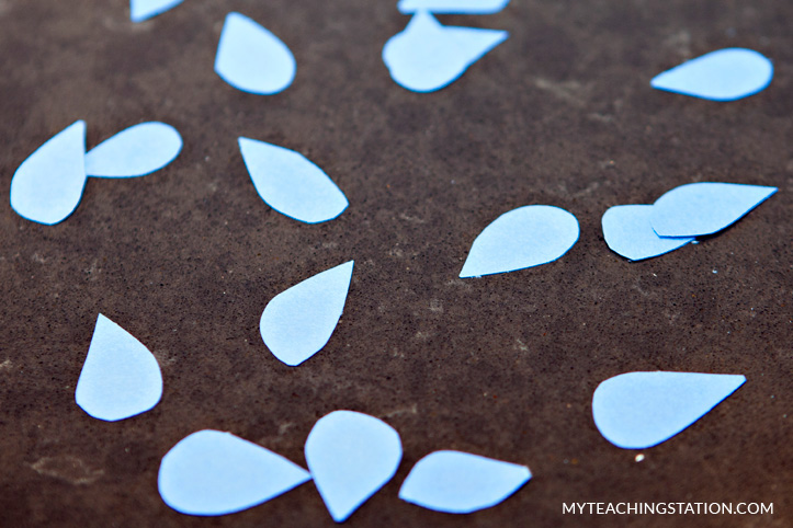 Use scissors to cut out the rain drops from the traced blue paper