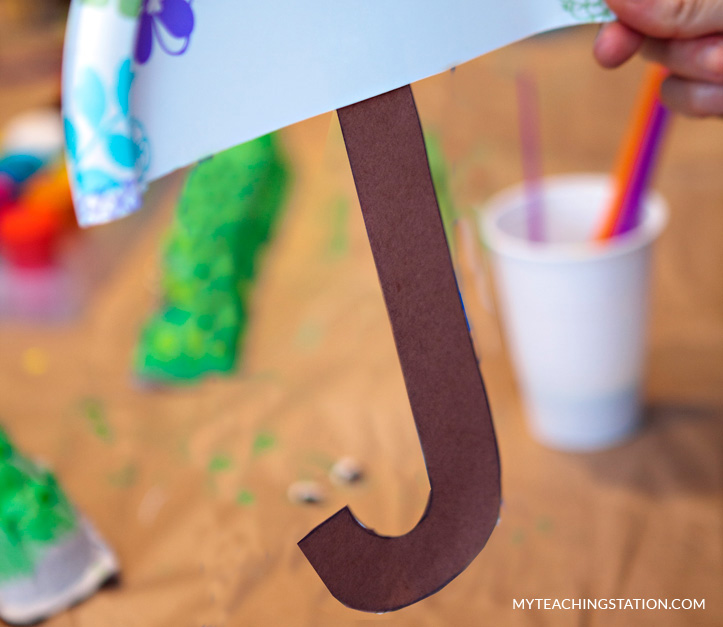 Trace and cut out the umbrella handle then glue it on the paper plate