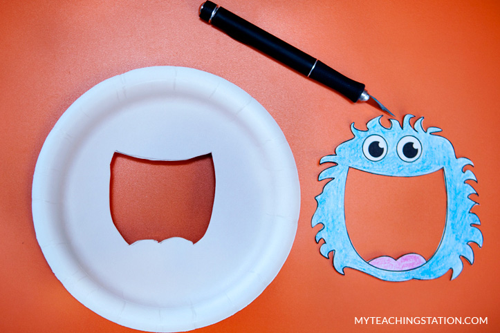 Cut paper plate to make alphabet finder magnifying glass.